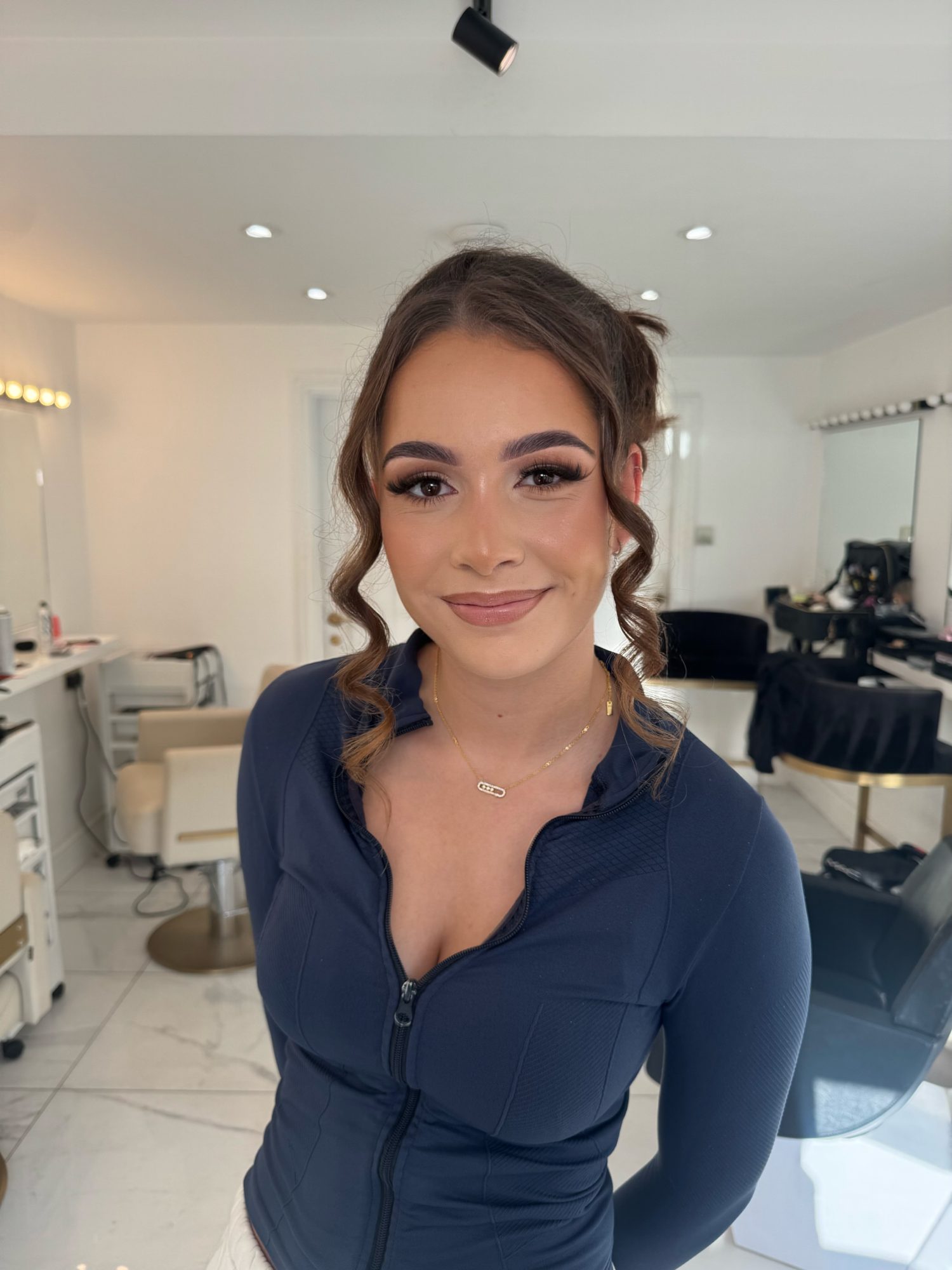 Bride having her makeup applied in a softly lit bridal suite